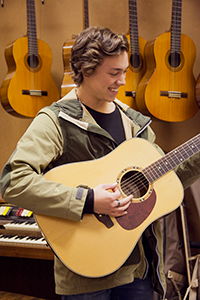A male student playing a guitar as part of his VET Music Industry program