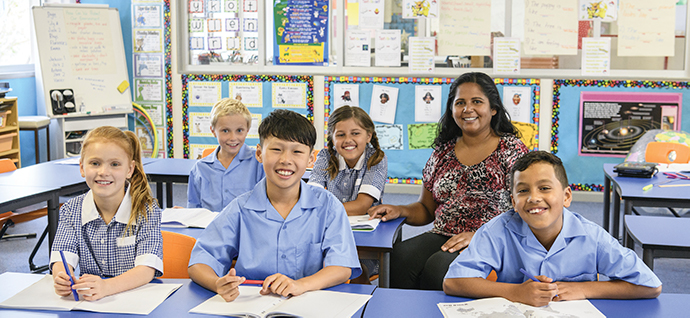 a female aboriginal teacher with young students in a classroom