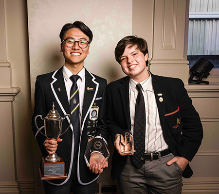 Two young men holding their trophies
