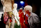 A man admires a garment on display on a mannequin in an indoor exhibition space