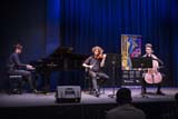 A pianist, a violinist, and a cellist perform onstage.