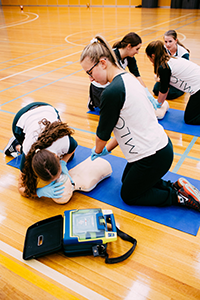 Students performing a CPR on a dummy